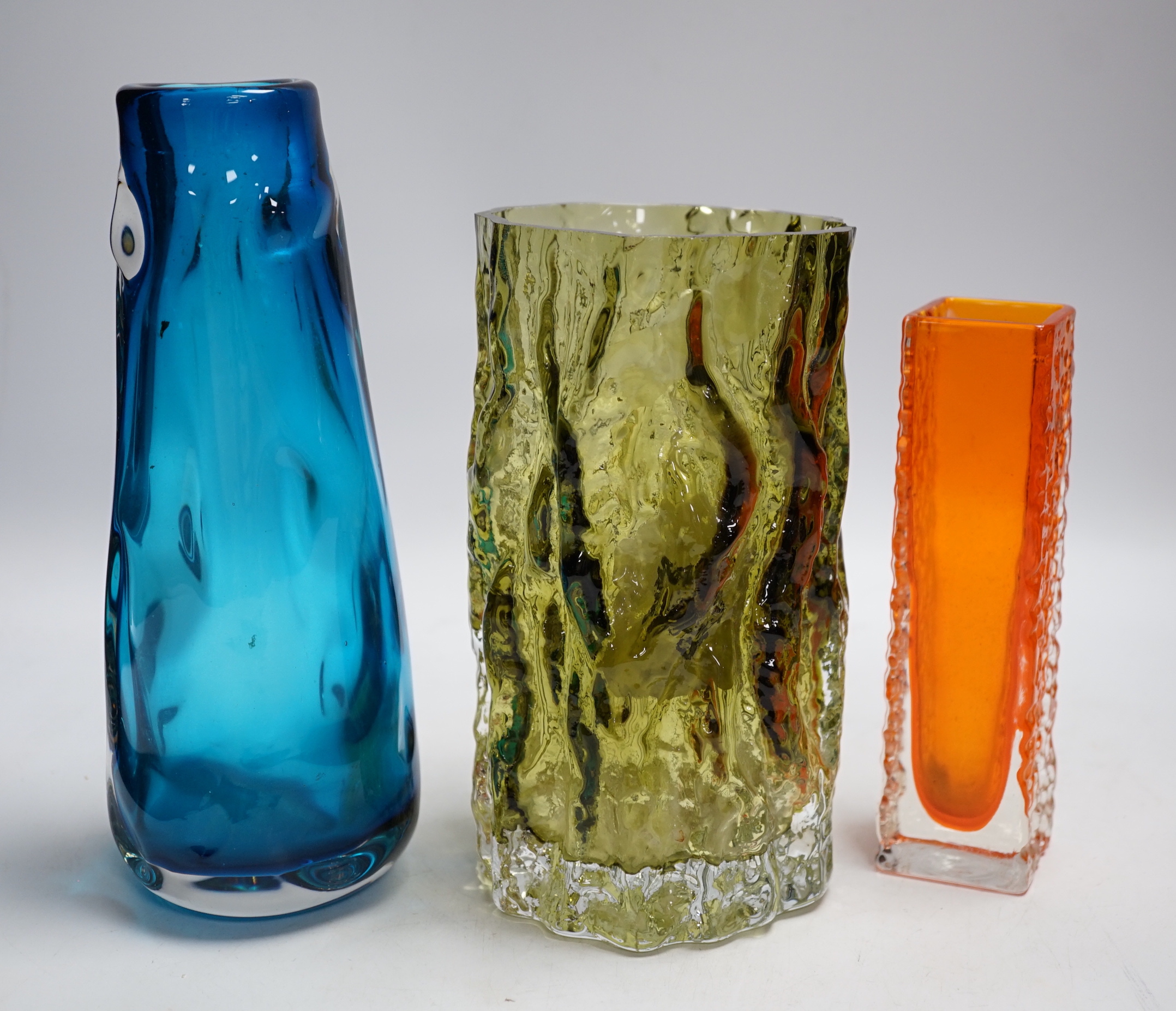 Three Whitefriars glass vases - a ‘Knobbly’ vase in kingfisher blue, a ‘Nailhead’ vase in tangerine and a ‘Bark’ vase in sage (cut down)